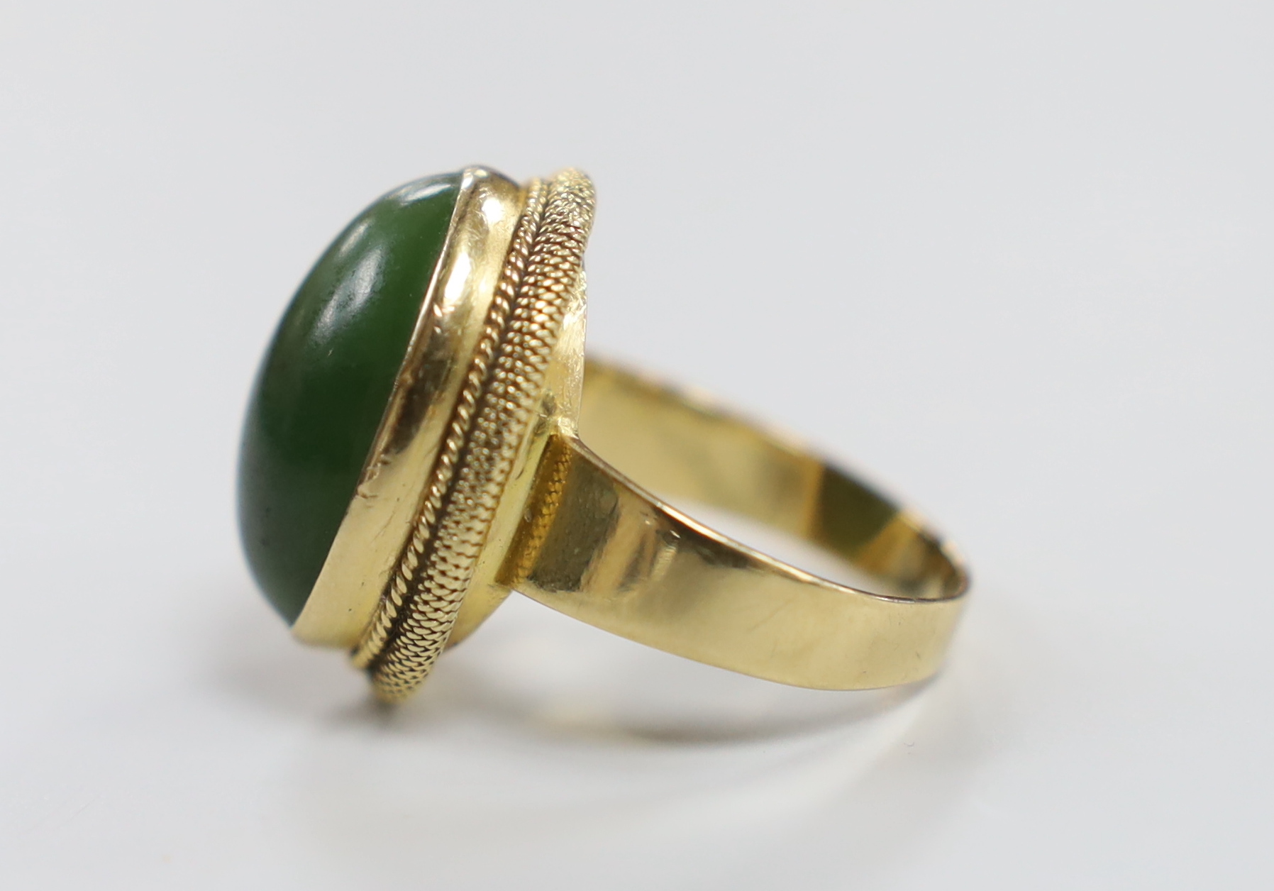 An 18k and cabochon spinach green nephrite green set dress ring. size Q/R